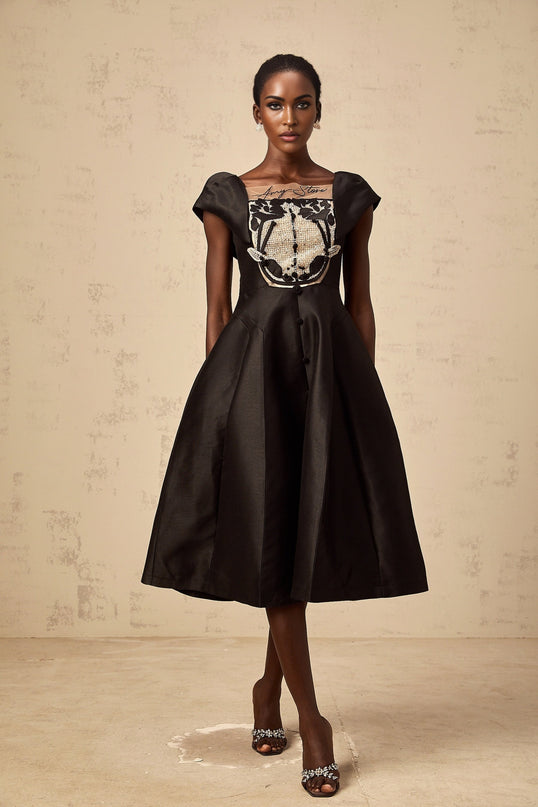 A black satin midi dress with floral applique details on the bodice and skirt named Ulrique