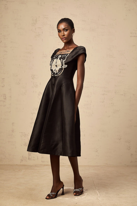 A black satin midi dress with floral applique details on the fabric