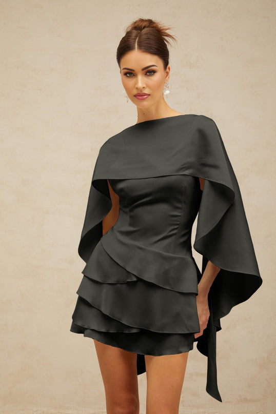 A black satin mini dress with ruffled details and a shawl panel accessory