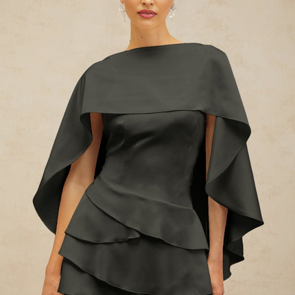 A black satin mini dress with ruffled details and a shawl panel feature worn by a model against a plain background