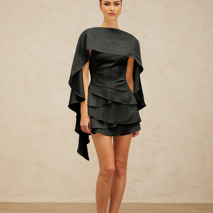 A black satin mini dress with ruffled details and a shawl panel featuring a sleek design and elegant appearance