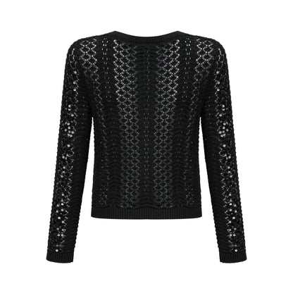 A black sequined cardigan and matching skirt set featuring crochet knit design The cardigan has long sleeves and an open front while the skirt is form fitting Both pieces are adorned with shimmering sequins throughout creating an elegant evening look