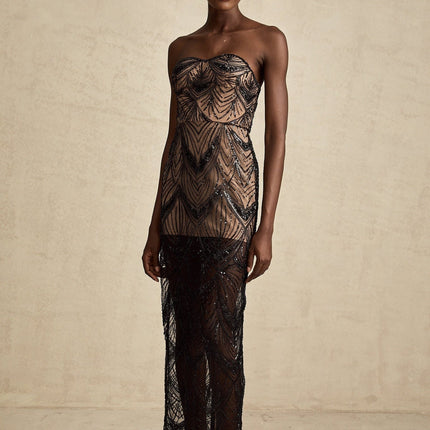 A black sequinned corset dress with a mesh maxi skirt featuring a fitted bodice and long flowy design