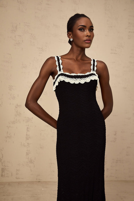 A black sleeveless midi dress with a crochet knit pattern covering the entire garment