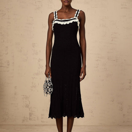 A black sleeveless midi dress with a crochet knit pattern throughout the garment
