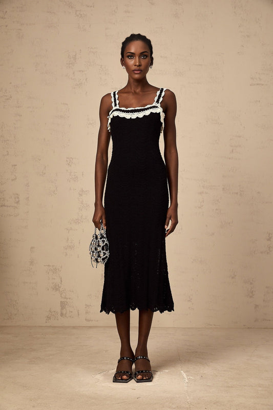 A black sleeveless midi dress with a crochet knit pattern throughout the garment