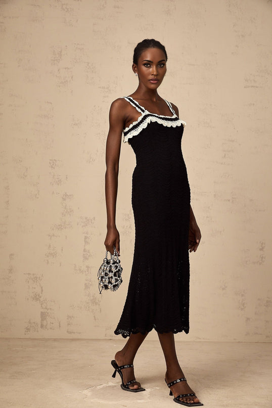 A black sleeveless midi dress with a crochet knit pattern