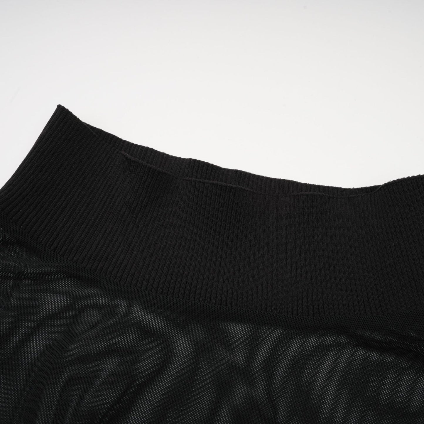 A black sleeveless top with a faux fur bodice and sheer tulle overlay