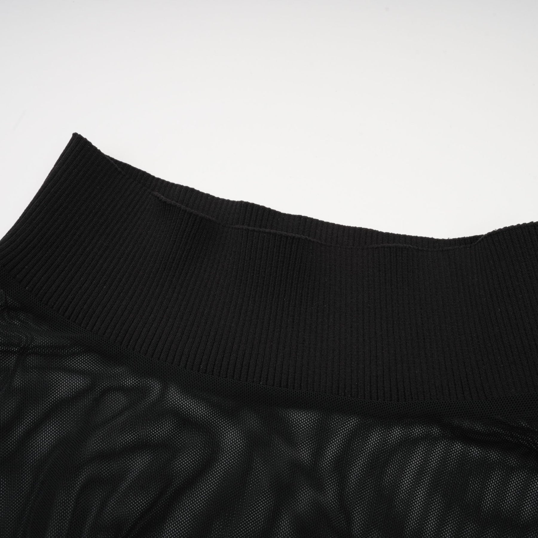 A black sleeveless top with a faux fur bodice and sheer tulle overlay