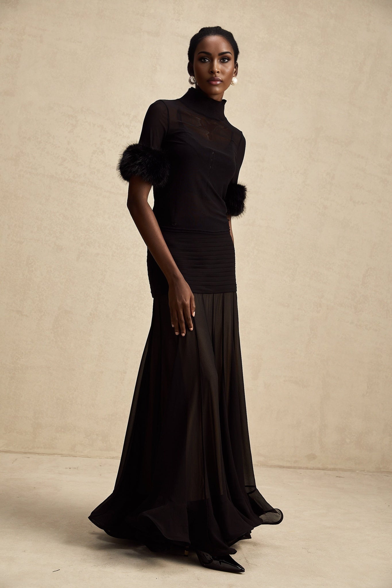 A black sleeveless top with a faux fur bodice and tulle overlay creating a fluffy textured appearance