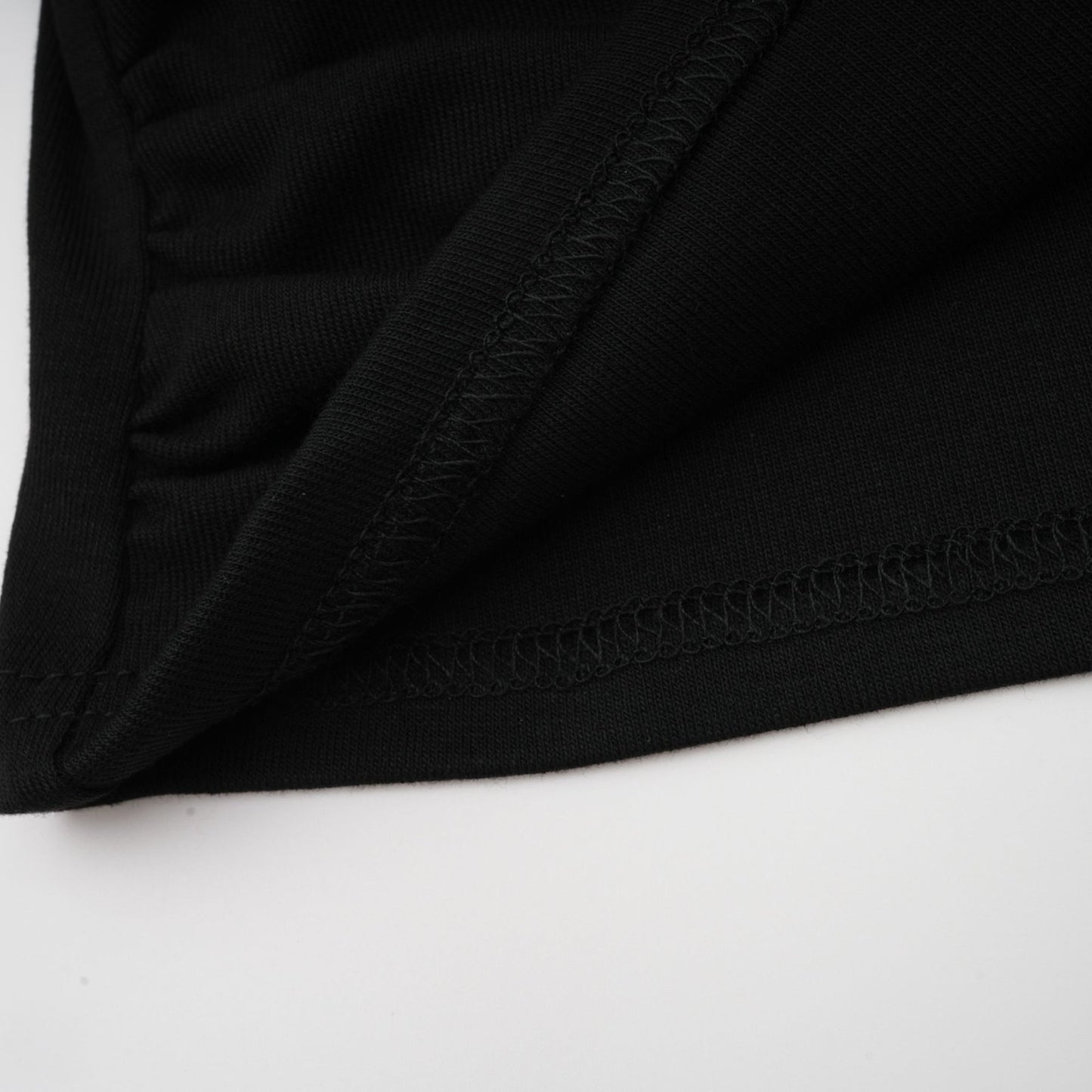 A black sleeveless top with an open front and gathered fabric details