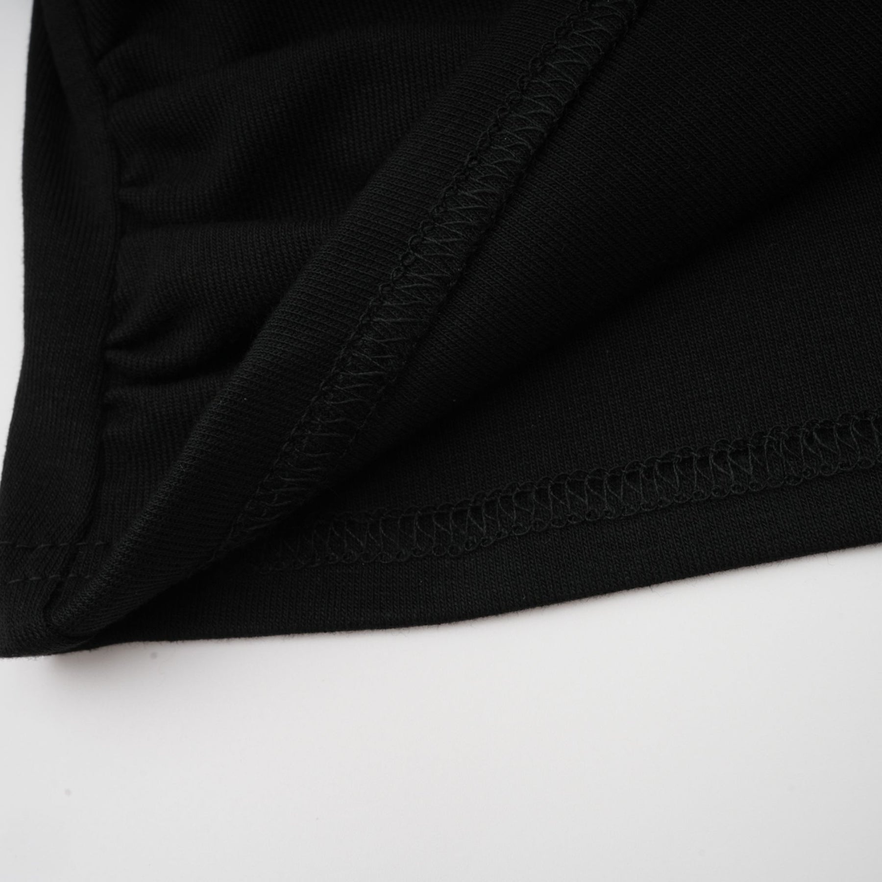 A black sleeveless top with an open front and gathered fabric details