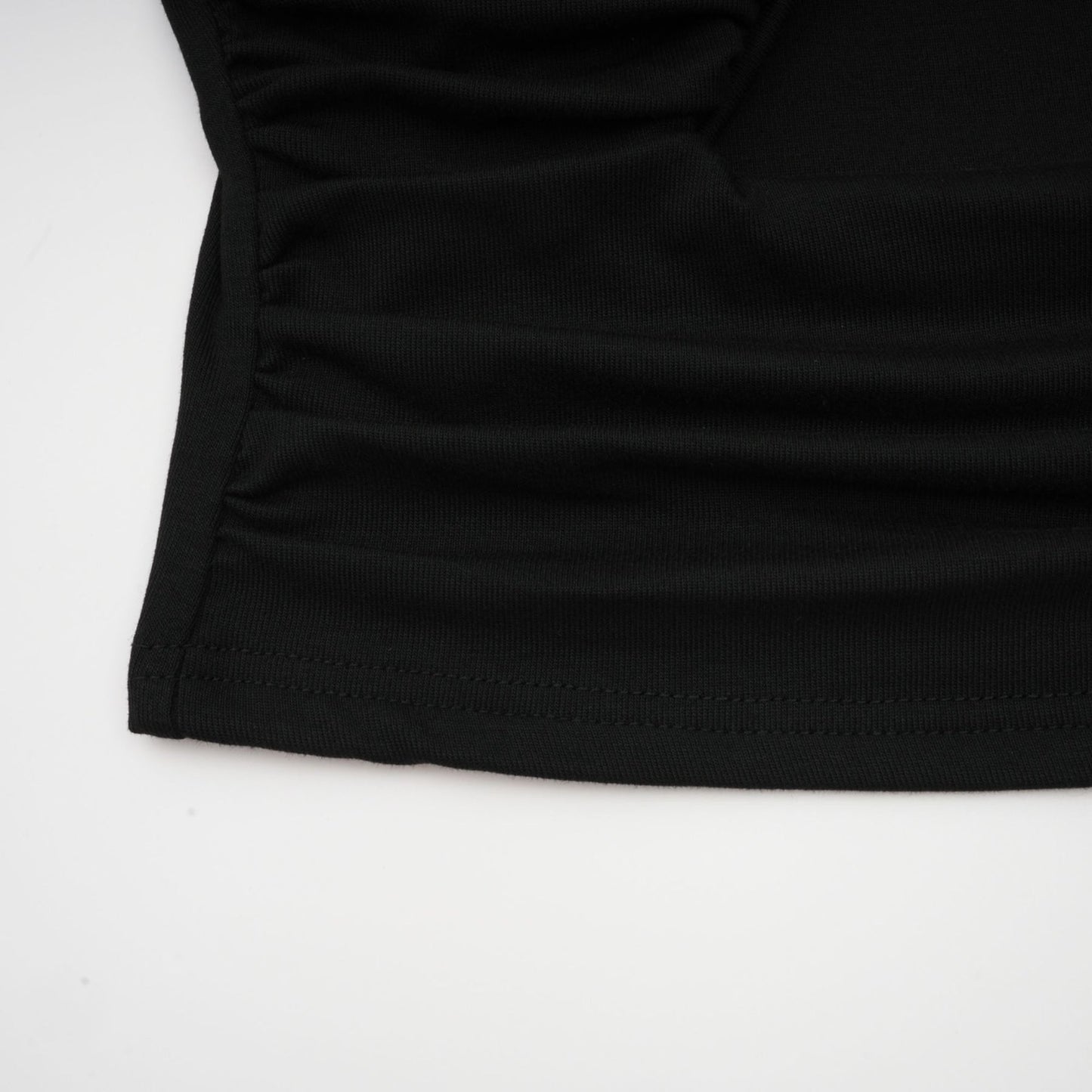 A black sleeveless top with an open front design and gathered fabric detailing