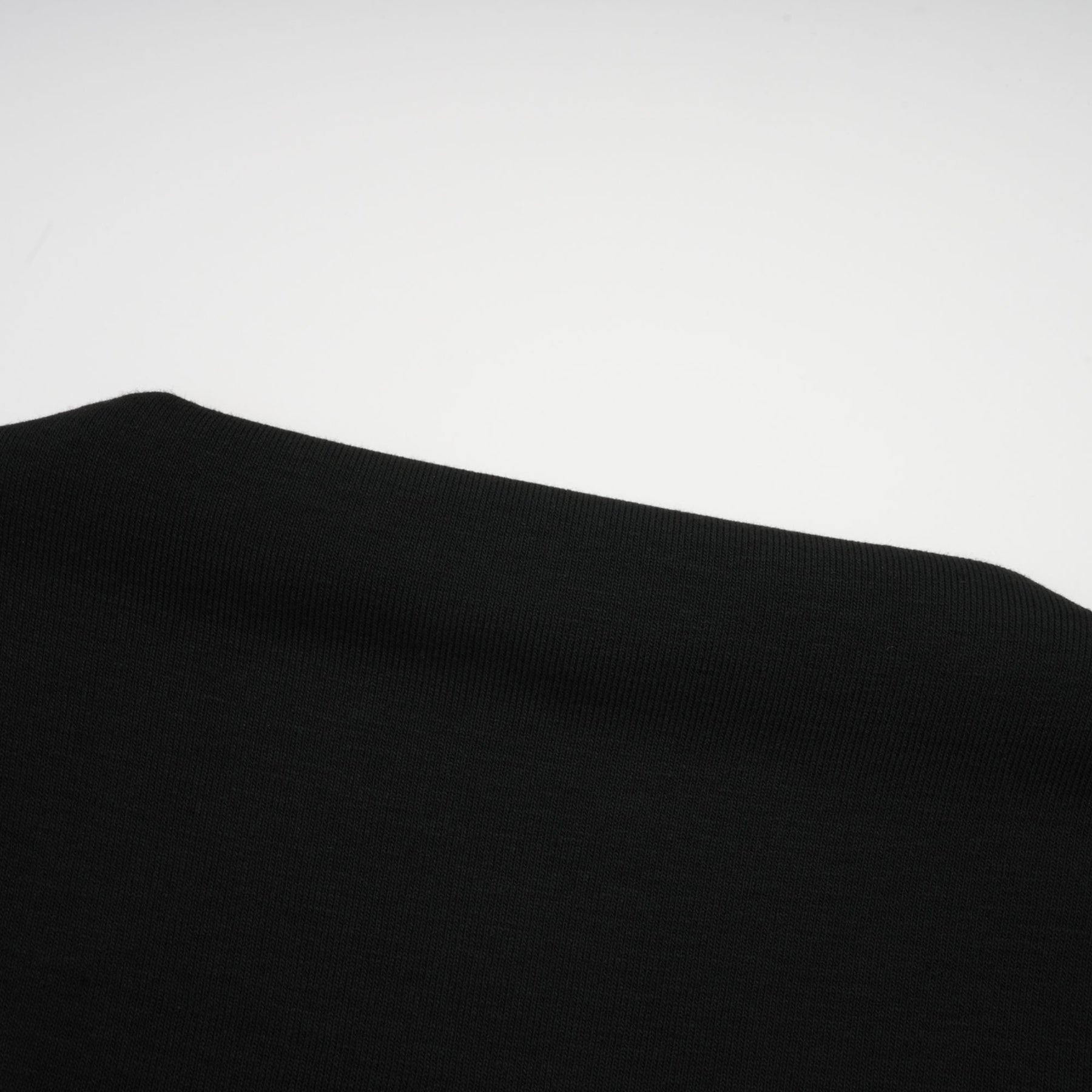 A black sleeveless top with an open front design and gathered fabric details