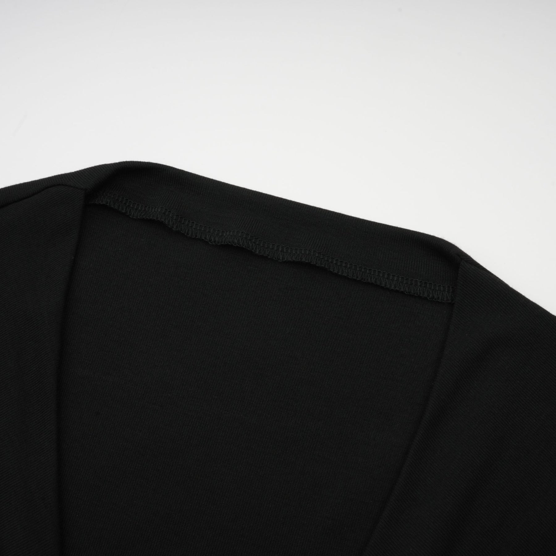 A black sleeveless top with an open front design featuring gathered fabric details