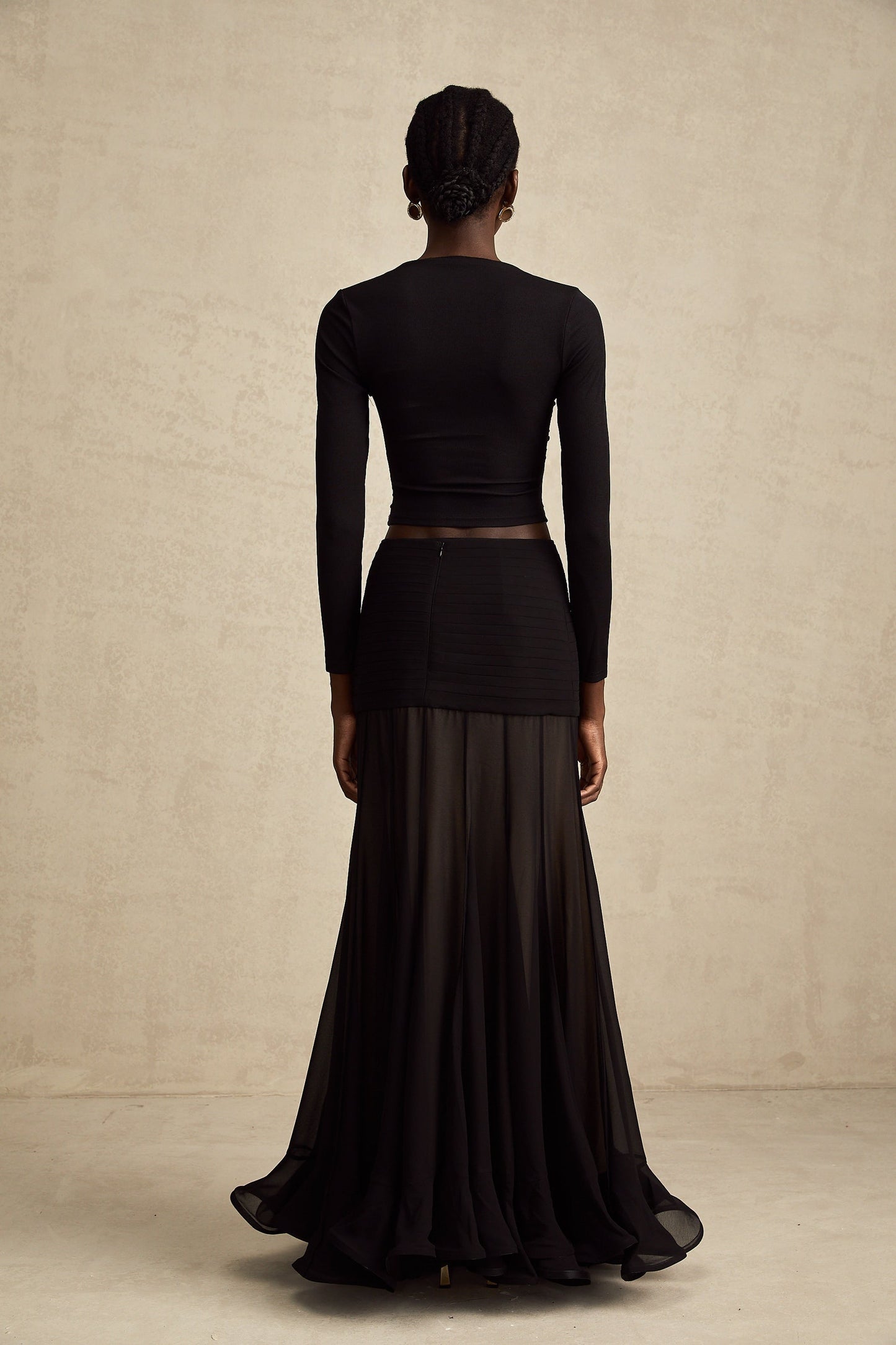 A black sleeveless top with an open front design featuring gathered fabric details