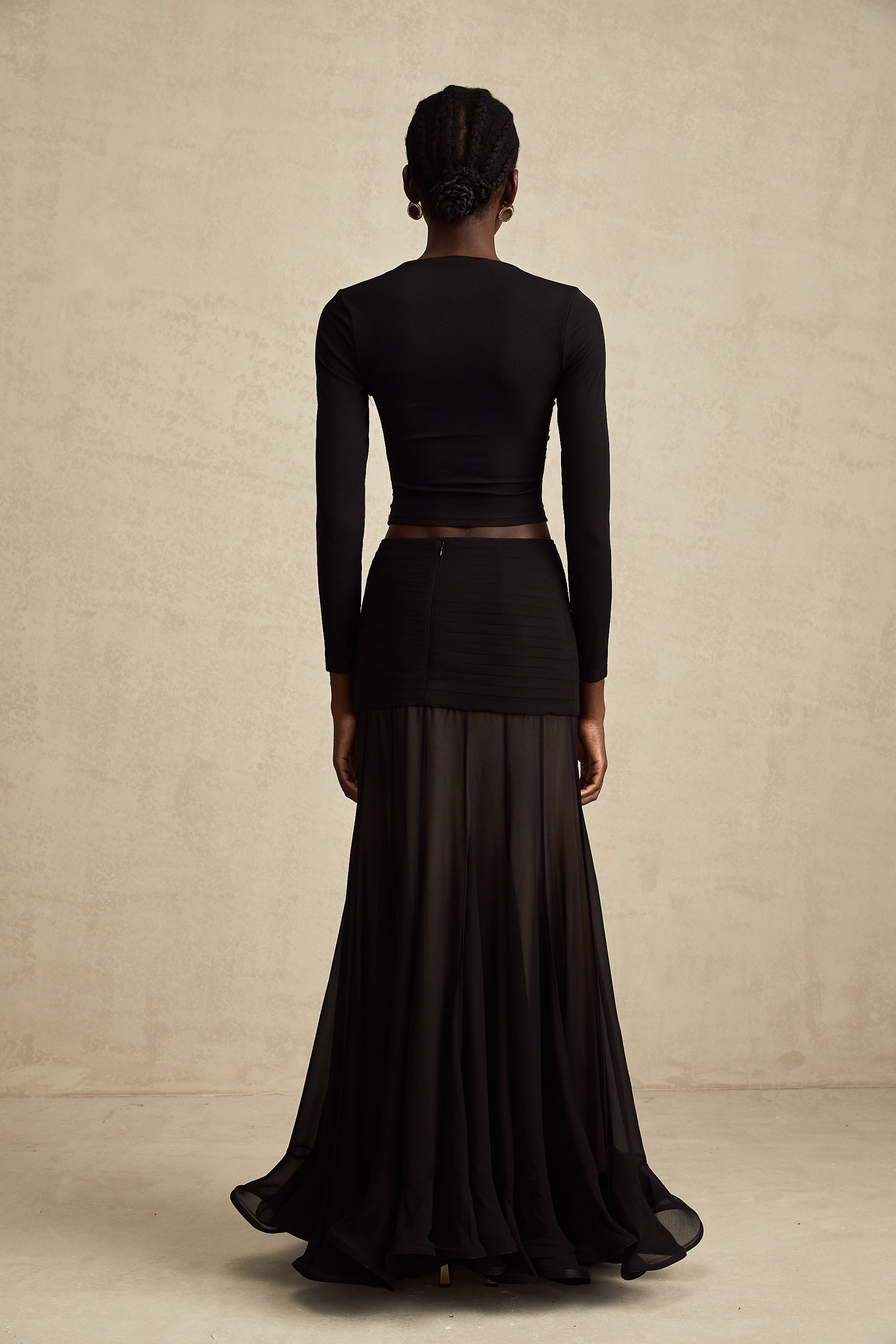 A black sleeveless top with an open front design featuring gathered fabric details