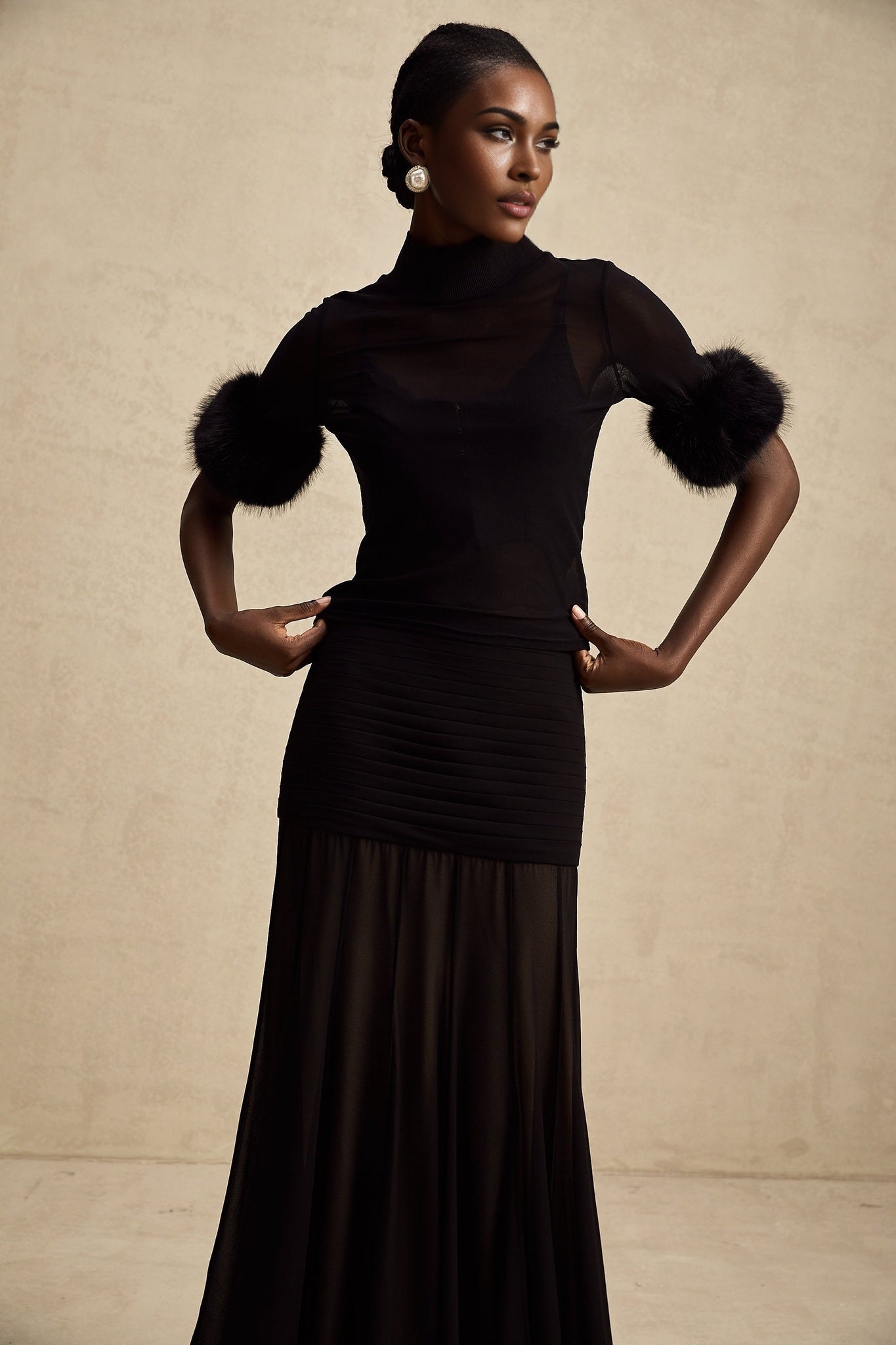A black sleeveless top with faux fur trim and sheer tulle overlay