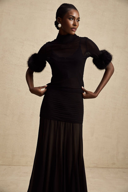 A black sleeveless top with faux fur trim and sheer tulle overlay
