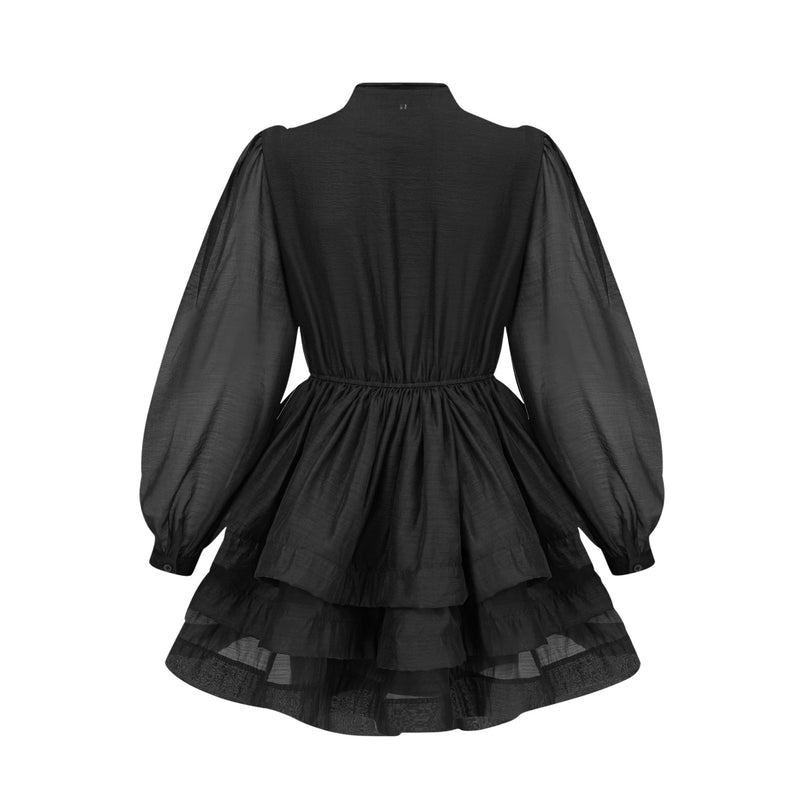 A black tiered flared mini dress with ruffled layers and short sleeves on a model against a plain background