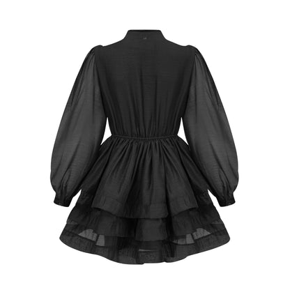 A black tiered flared mini dress with ruffled layers and short sleeves on a model against a plain background
