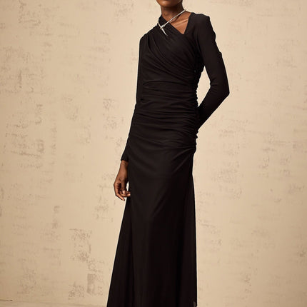 A black tulle maxi dress with asymmetric design and cutout details modeled by a woman