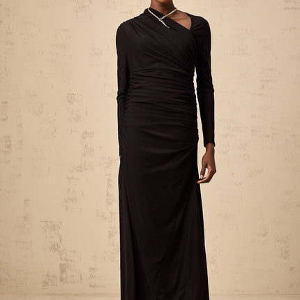 A black tulle maxi dress with asymmetric design and cutout details worn by a model named Natalie
