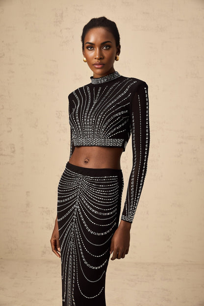 A black twopiece outfit consisting of a mesh top and skirt adorned with rhinestones The set features a sleeveless top and a fitted skirt both embellished with sparkling details for a glamorous look