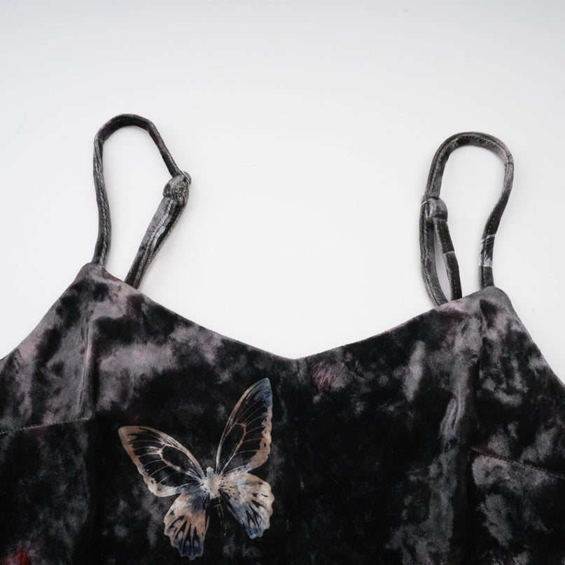 A black velvet midi dress with a butterfly print pattern featuring a fitted silhouette and long sleeves