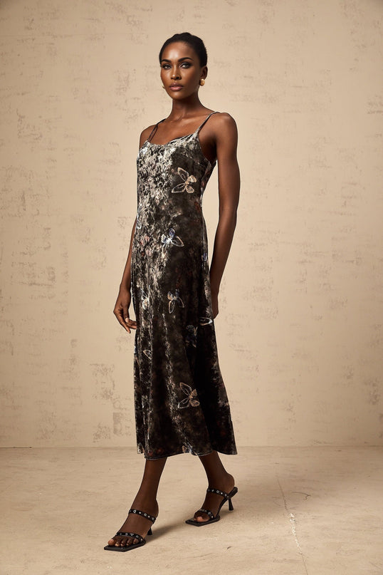 A black velvet midi dress with a butterfly print pattern featuring long sleeves and a fitted silhouette