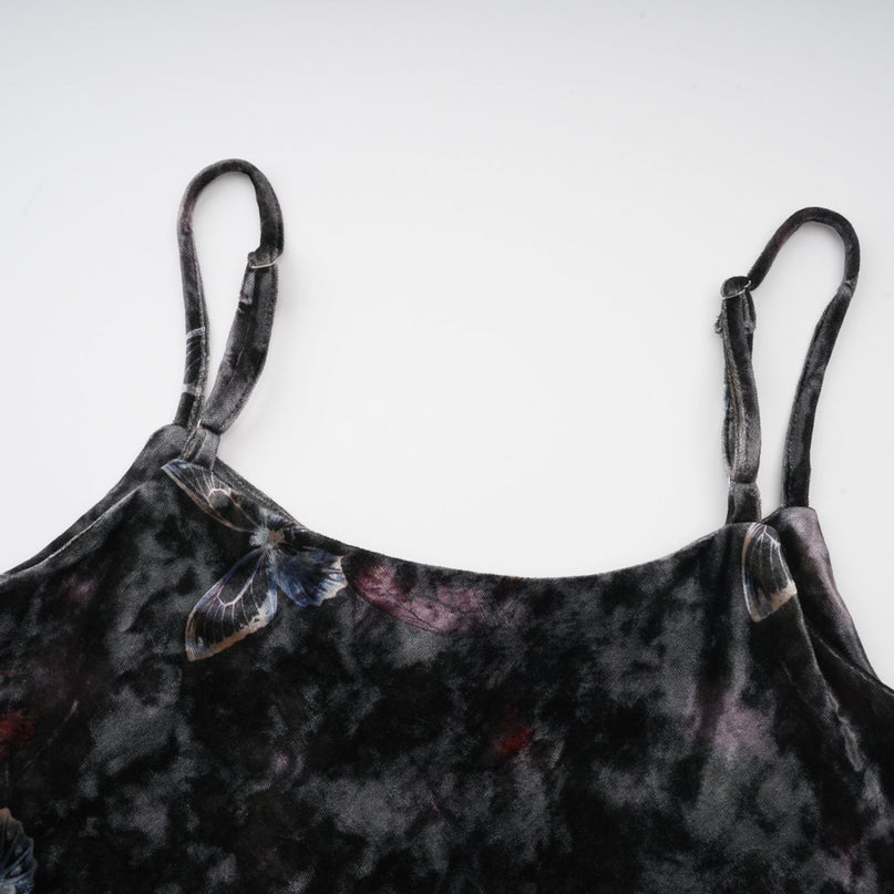 A black velvet midi dress with a butterfly print pattern featuring long sleeves and a flowy silhouette