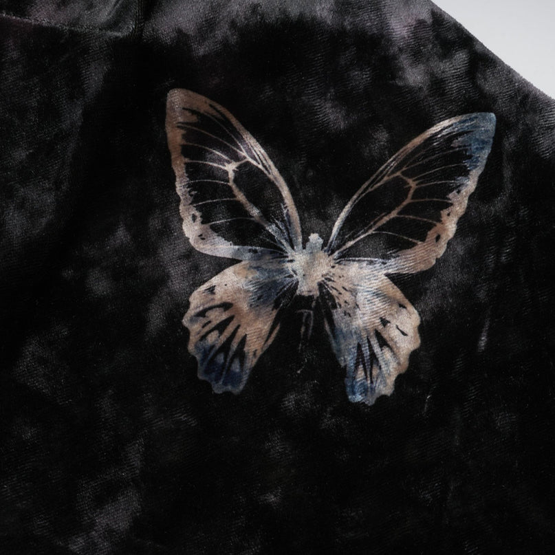 A black velvet midi dress with a butterfly print pattern featuring long sleeves and a flowy silhouette