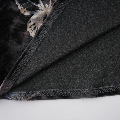 A black velvet midi dress with a butterfly print pattern named Blanche on a plain background