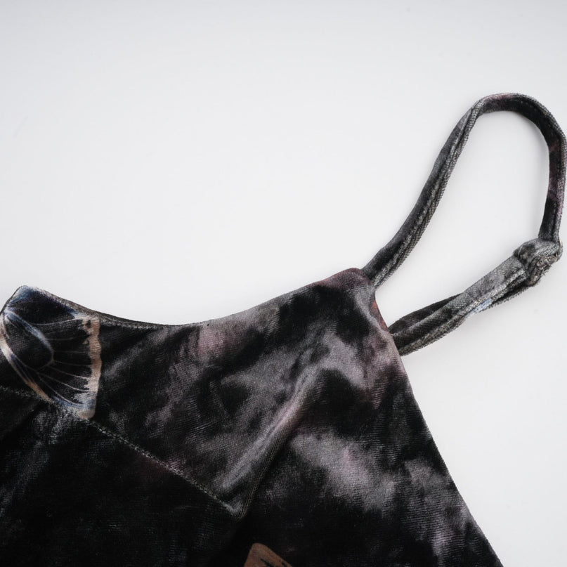 A black velvet midi dress with a butterfly print pattern worn by a model standing against a plain background