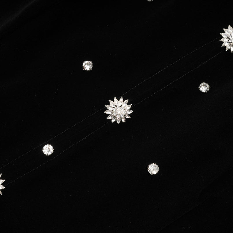 A black velvet midi dress with embellishments named Lola featuring a fitted silhouette and elegant design