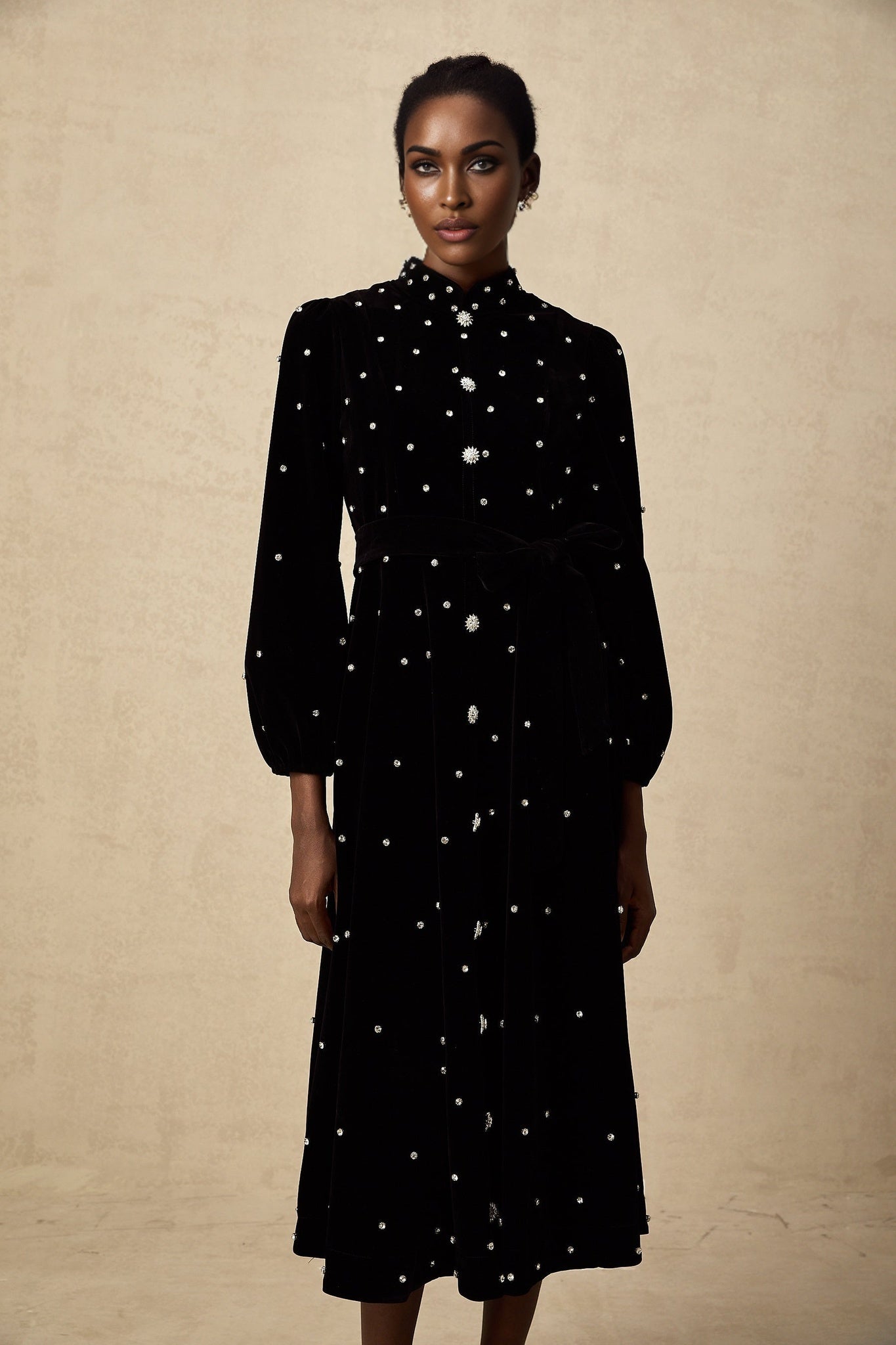 A black velvet midi dress with embellishments named Lola featuring a sleek design and elegant appearance