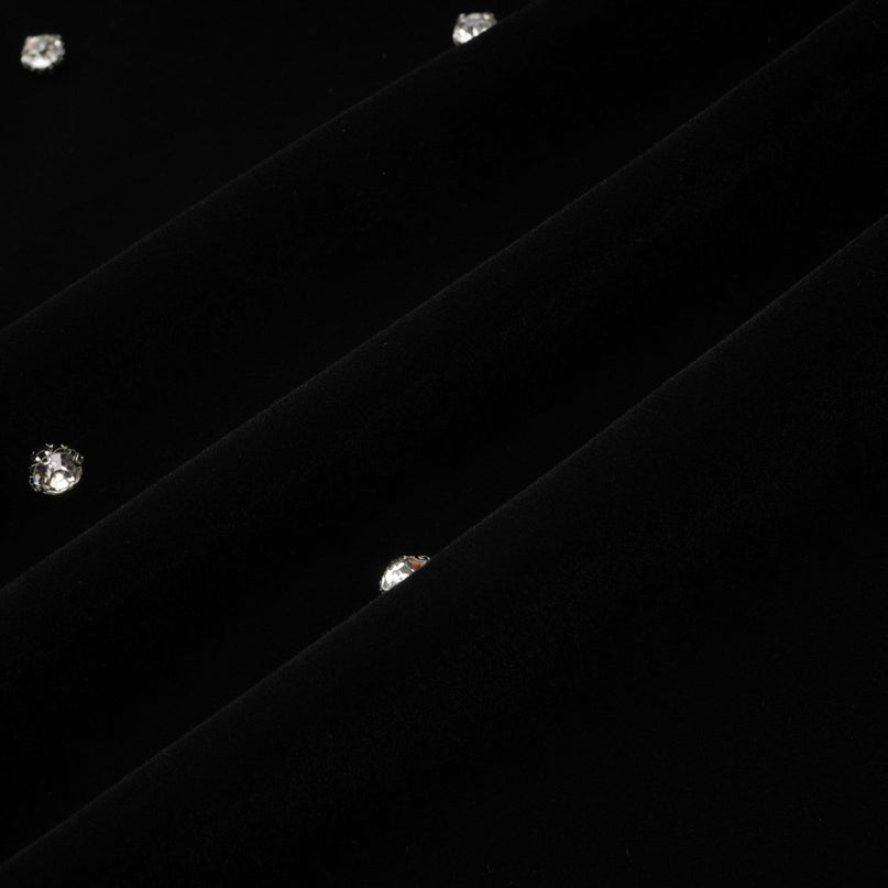 A black velvet midi dress with embellishments named Lola featuring a sleek silhouette and elegant design