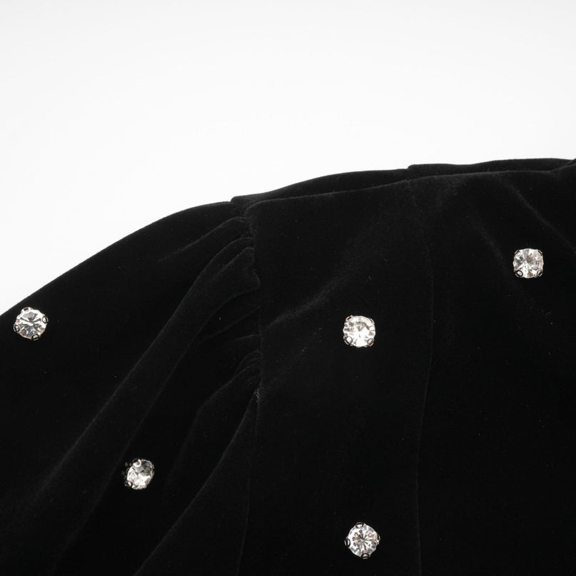 A black velvet midi dress with embellishments named Lola featuring a sleek silhouette and elegant design