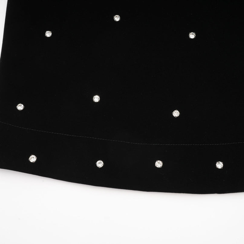 A black velvet midi dress with embellishments named Lola worn by a model against a plain background