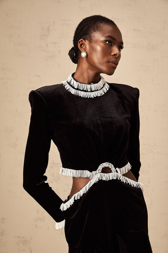 A black velvet mini dress with cut out details and fringe accents named Daniela
