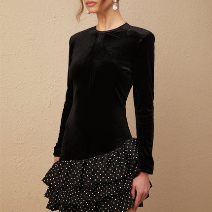 A black velvet mini dress with polka dot print featuring ruffled panels and a short hemline