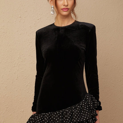 A black velvet mini dress with polka dot print featuring ruffled panels and a short hemline