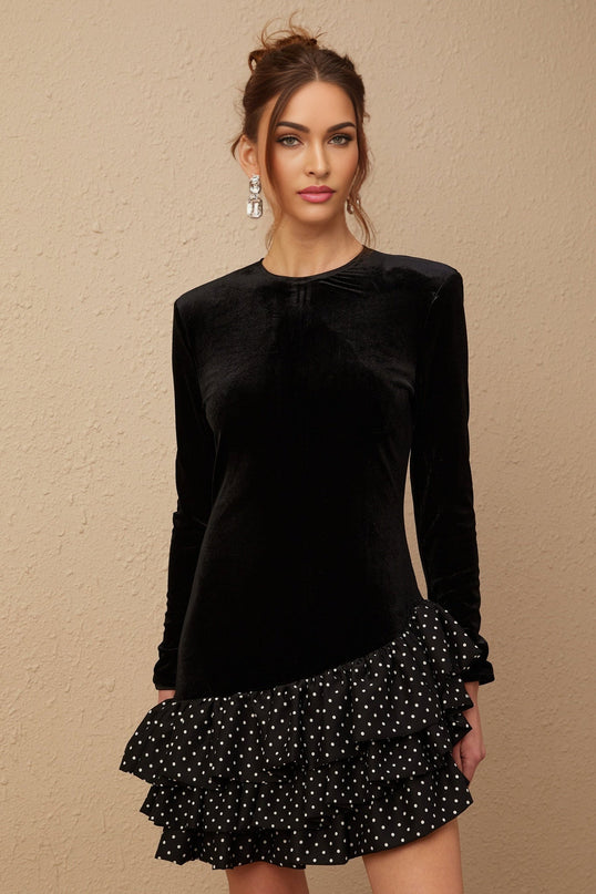 A black velvet mini dress with polka dot print featuring ruffled panels and a short hemline