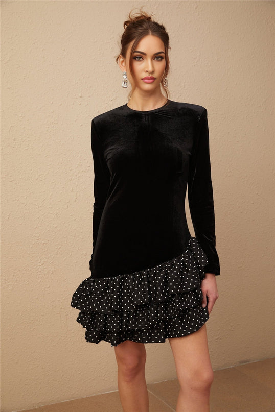 A black velvet mini dress with white polka dots featuring ruffled panels and a short hemline named Lucrezia