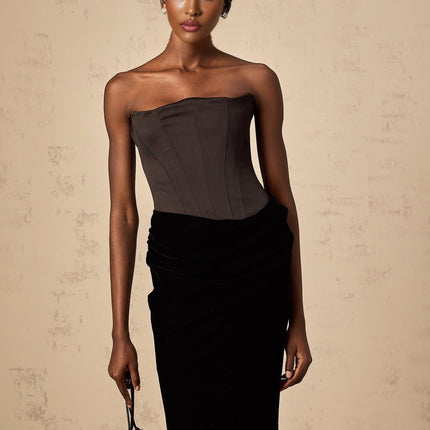 A black velvet off shoulder maxi dress with a fitted bodice and long flowing skirt