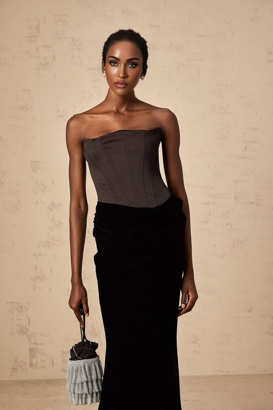 A black velvet off shoulder maxi dress with a fitted bodice and long flowing skirt