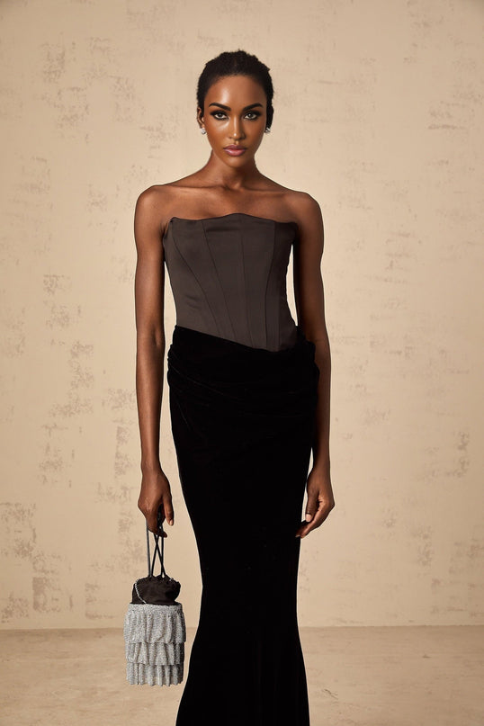 A black velvet offshoulder maxi dress with a formfitting silhouette and long sleeves