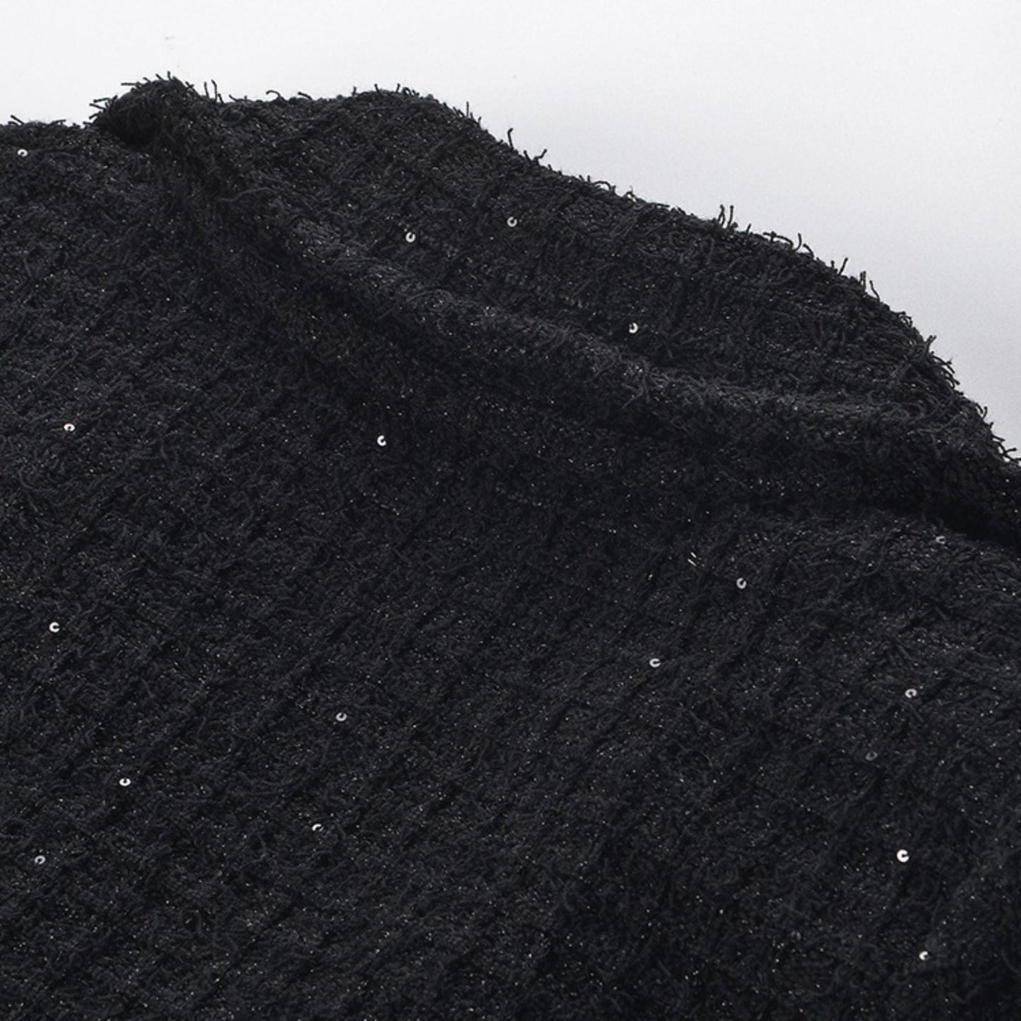 Black jacket with long sleeves notched lapels two front patch pockets front button fastening and waffleknit texture Made of 80% polyester 20% cotton Black skirt with pleated edge and waffleknit detail Composed of 80% polyester 20% cotton