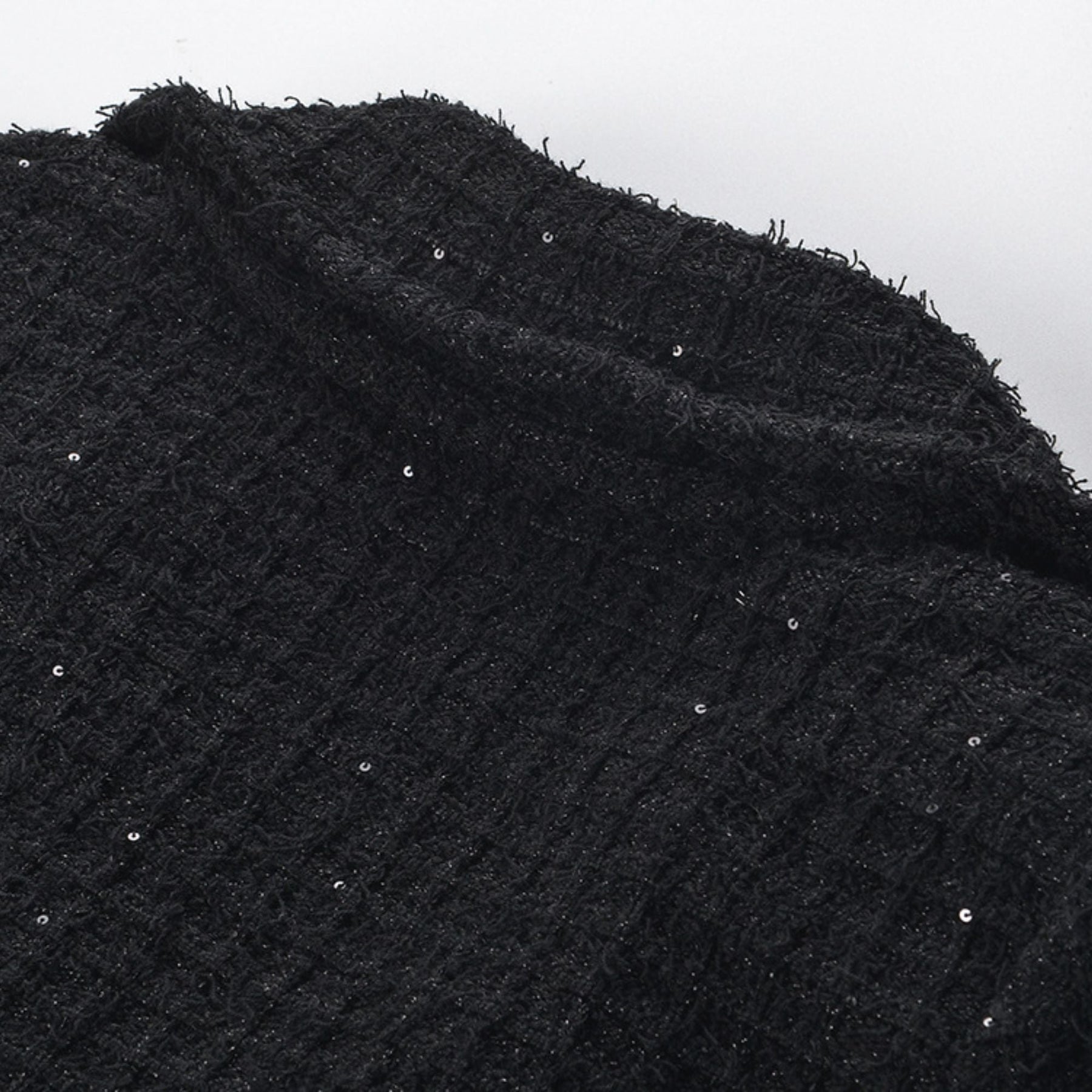 Black jacket with long sleeves notched lapels two front patch pockets front button fastening and waffleknit texture Made of 80% polyester 20% cotton Black skirt with pleated edge and waffleknit detail Composed of 80% polyester 20% cotton