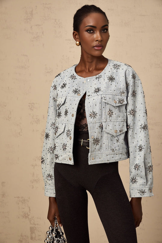 A blue denim jacket with sun motif studs decorating the fabric Katell brand visible on the garment